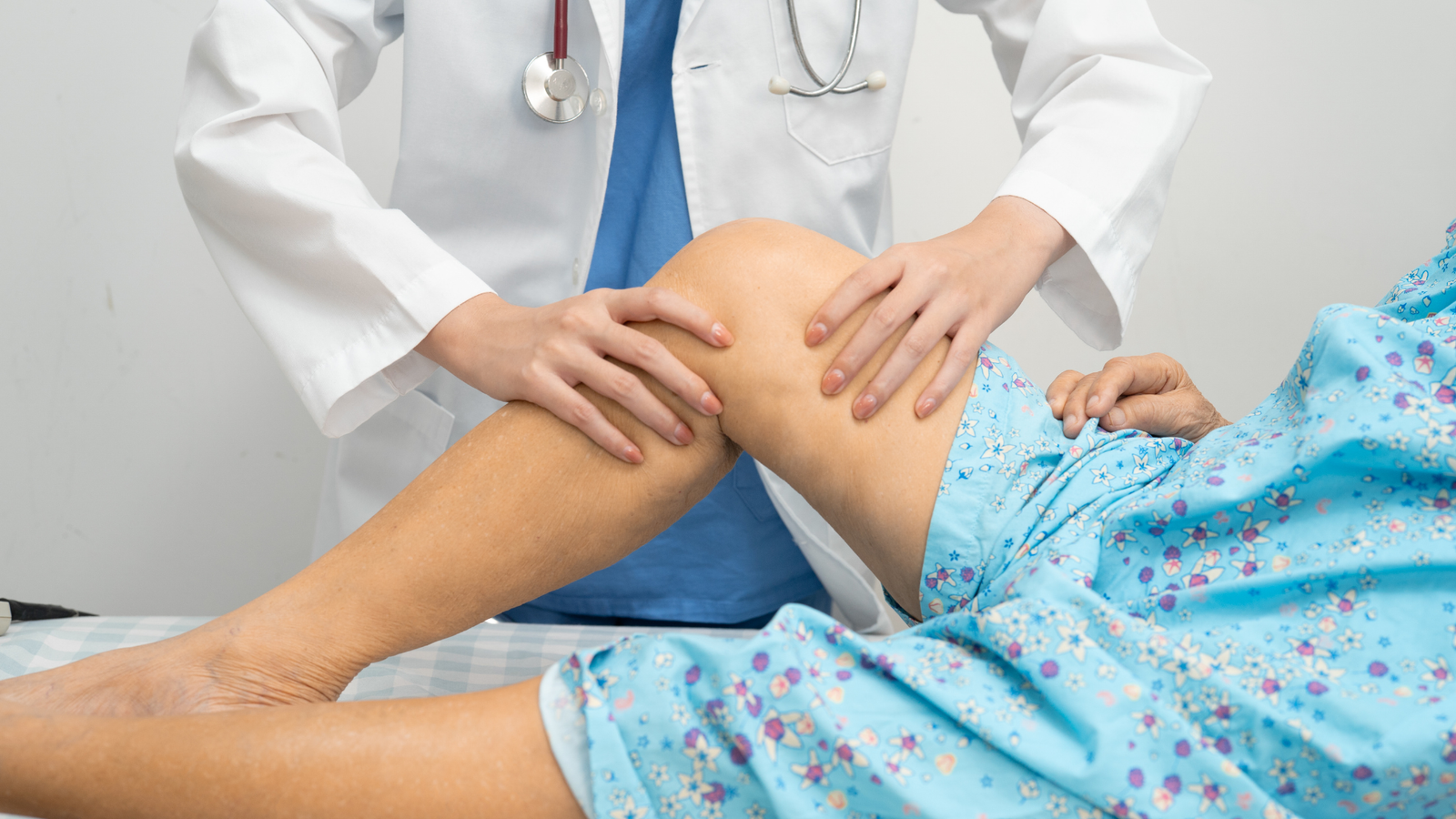 A senior patient walking comfortably with a physical therapist after undergoing a successful total knee replacement surgery.